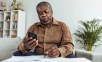 A man doing accounting work making a displeaased face