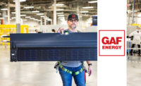 A man holding an element of GAF Energy’s Timberline Solar shingle system (pictured).