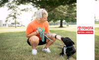 An employee from Toyota Material Handling sitting with a dog.