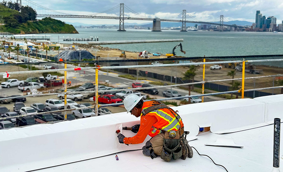 A roofing contractor with Tecta America puts the finishing touches on a TPO installation job in San Francisco