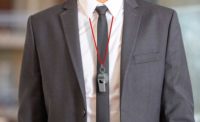 A gray business cuit and tie with a coach's whistle