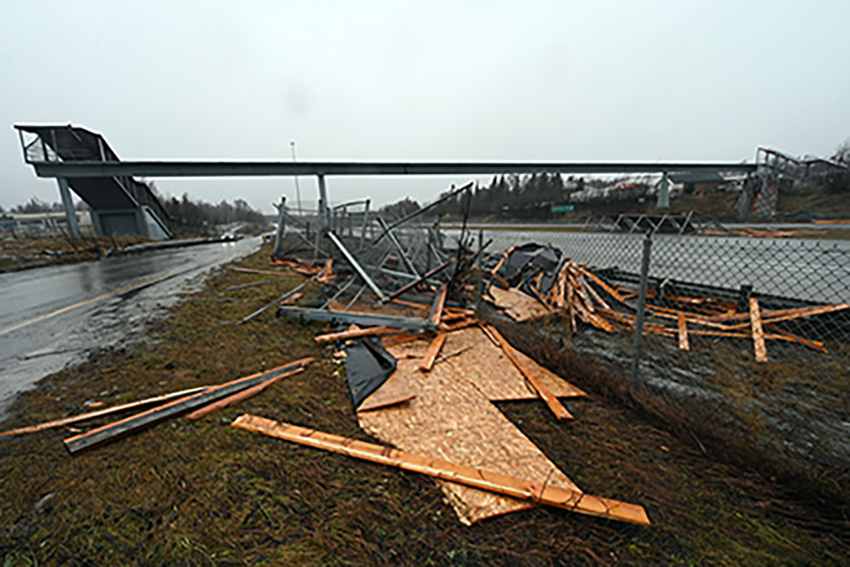 A pedestrian bridge spanning the Seward Highway in Anchorage, Alaska, partially collapsed onto the roadway.